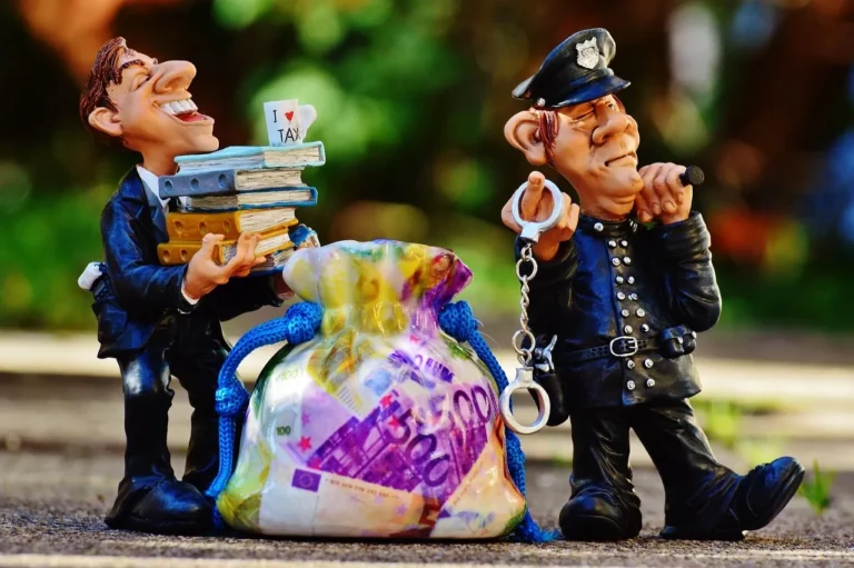 Accountant holding books bag of cash beside him. policeman beside him holding a pair of handcuffs